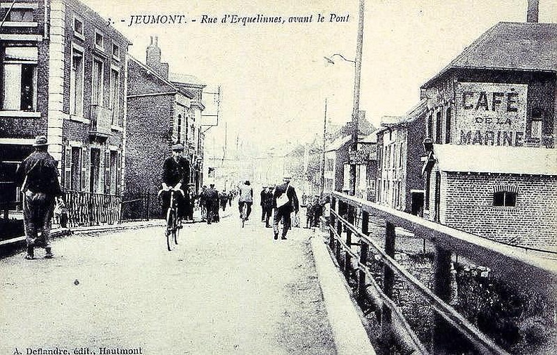 Sur la droite, se trouve une barrière provisoire du pont.
Avant le café de la Marine se trouvait une aubette (abris) de la douane.
Sur la gauche cette bâtisse était probablement un commerce.
En vue de la population abondante on peut penser que cette photo fût prise lors d'une sortie d'usine.
Photo prise vers 1900. Jaures_21.jpg